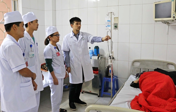 Thượng úy Lương Minh Hoàng (đứng ngoài cùng, bên phải) giới thiệu “Hệ thống theo dõi và cảnh báo dịch truyền cho bệnh nhân từ xa” tại Khoa Hồi sức cấp cứu.